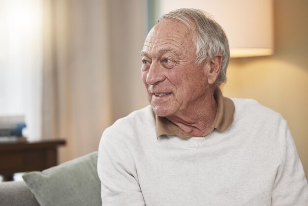 Он наслаждается жизнью на пенсии. Снимок пожилого мужчины, сидящего дома на диване.