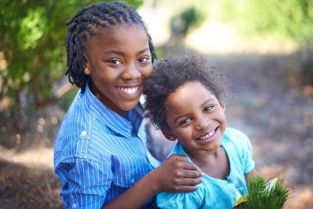 Hes an excellent big brother Cute african american siblings spending time together in nature