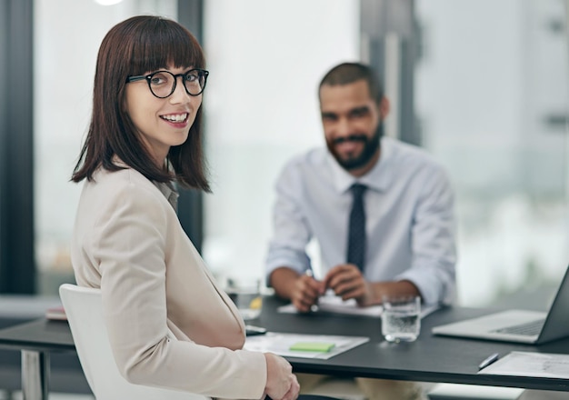 彼は私と会社にとって大きな資産ですオフィスで男性の同僚と一緒に働いている若い実業家の肖像画を切り取った