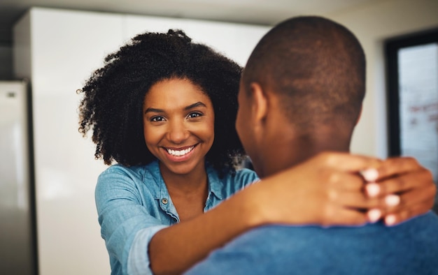 Photo hes my everything portrait of a cheerful young couple holding each other and sharing a tender moment in the kitchen at home during the day