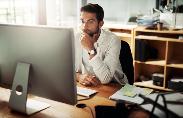 Hes never missed a deadline Shot of a handsome young businessman working late on a computer in an office