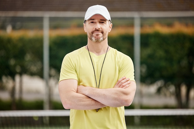 Photo hes one confident coach cropped portrait of a handsome mature male tennis coach standing with his arms folded on the court