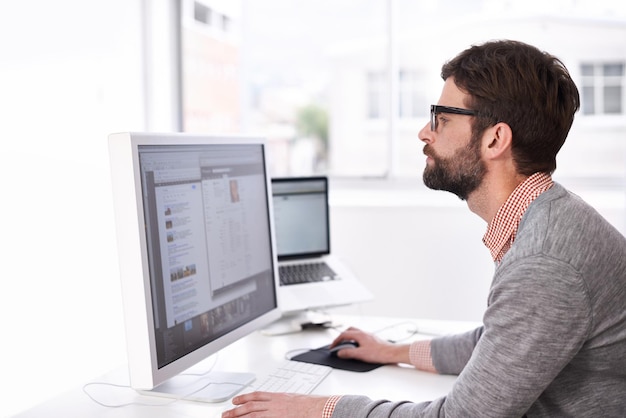 Hes on the project A handsome young man at his desk in an office