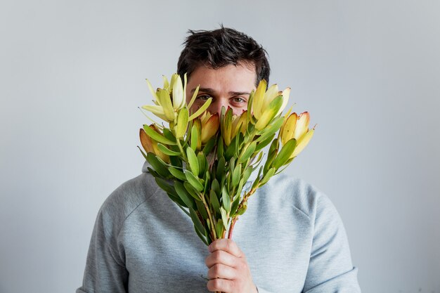 日没のサファリの花を持つ男をためらう