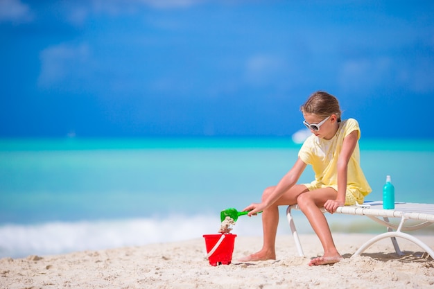 Het aanbiddelijke meisje spelen met speelgoed op strandvakantie. Kid spelen met zand