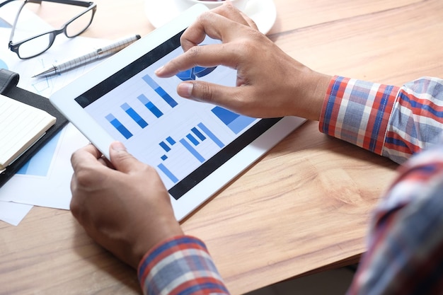 Foto het analyseren van financiële kaarten op een digitale tablet met behulp van zelf gemaakte kaarten