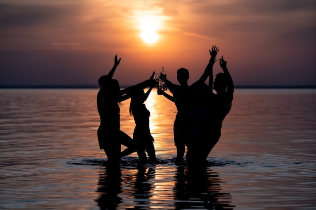 Het avondstrandfeest tegen de zonsondergang