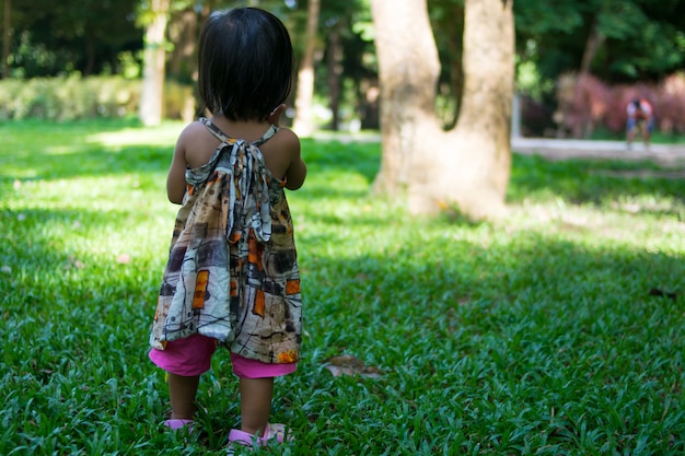 Het Aziatische babymeisje spelen in tuin