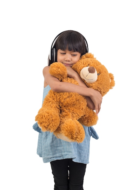 Het Aziatische meisje koestert een teddybeer op een wit