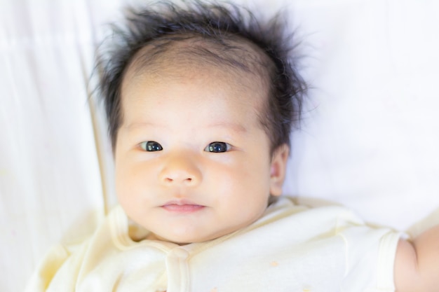 Het babymeisje in schone doek bepaalt op bed na afwerkingsdouche