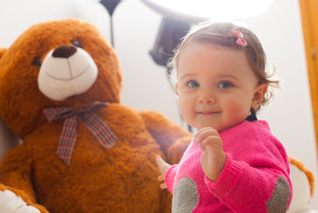 Het babymeisje van de peuter het spelen met grote teddybeer