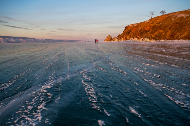 Het Baikalmeer is bedekt met ijs en sneeuw, sterke koude, dik helderblauw ijs. IJspegels hangen aan rotsen