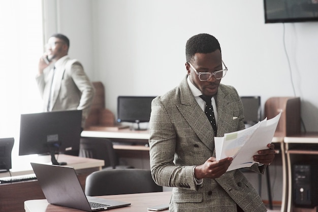 Het beeld van twee jonge Afro-Amerikaanse zakenmensen die interactie hebben tijdens een vergadering op kantoor