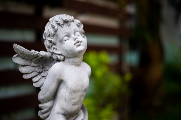 Het beeldhouwwerk van de close-upcupido in tuin