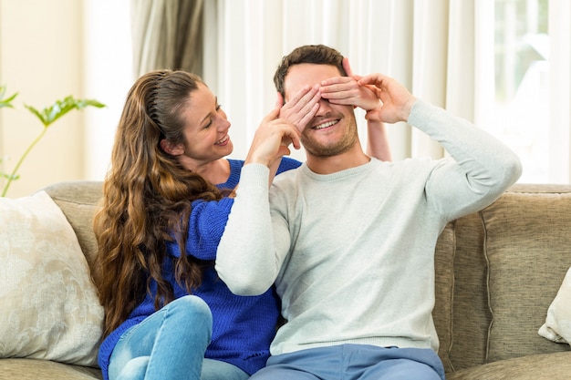 Het behandelen van de vrouw bemant ogen in woonkamer