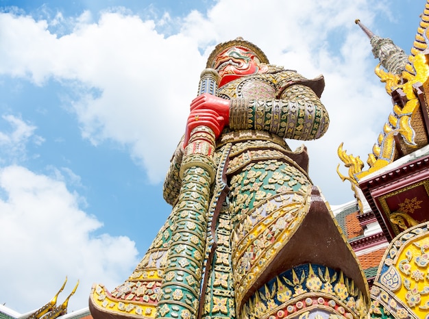 Het bekijken omhoog reusachtig standbeeld bij groot paleis, tempel van emerald buddha (pra van wat kaew) in bangkok, thailand.