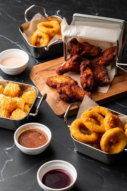 Het bierbord met pittige kippenvleugels calamaresringen friet uienringen kaasballetjes gepaneerde aardappelen