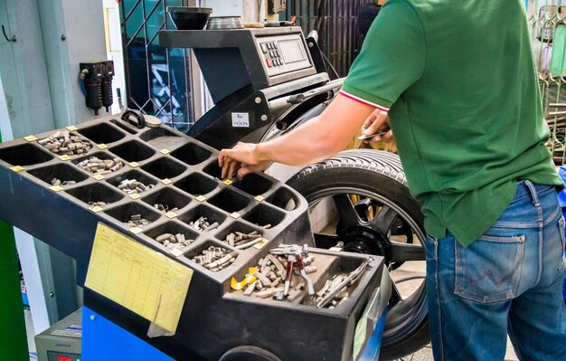 Foto het binnenland van een autoreparatiewerkplaats, arbeider herstelt een auto in een autoreparatiecentrum