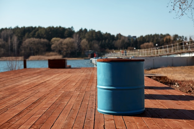 Foto het blauwe vat staat op de oever van het meer op een houten pier. lente landschap.