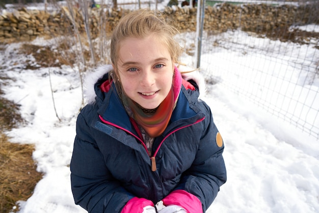 Het blonde meisje spelen met sneeuwbal in de winter