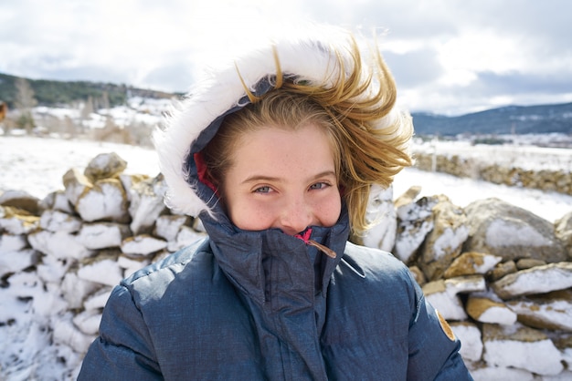 Het blonde meisje spelen met sneeuwbal in de winter