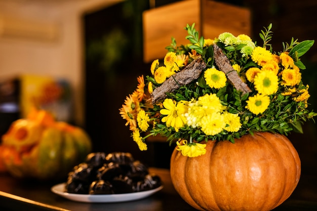 Het boeket van herfstbloemen in de pompoen op de viering van Halloween