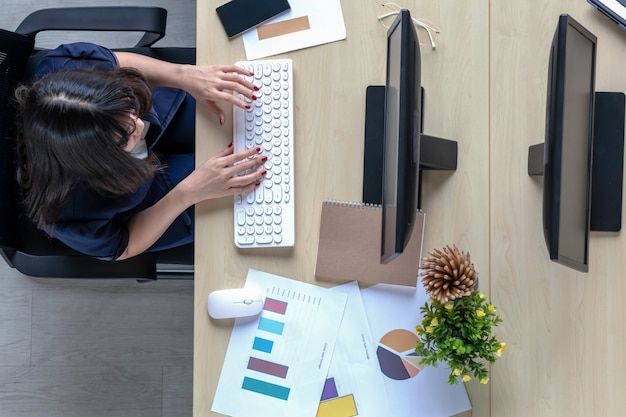 Het bovenaanzicht van een vrouw die aan een bureau zit