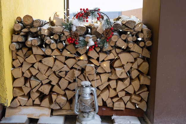 Het brandhout op de besneeuwde veranda van het huis wordt geoogst voor de winter. Verwarming van woningen met een open haard, bespaart elektriciteit en gas in een crisis milieuvriendelijkheid.