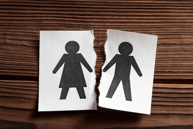 Het breken van relaties echtscheiding in het gezin Papier wordt in tweeën gescheurd met het symbool van man en vrouw