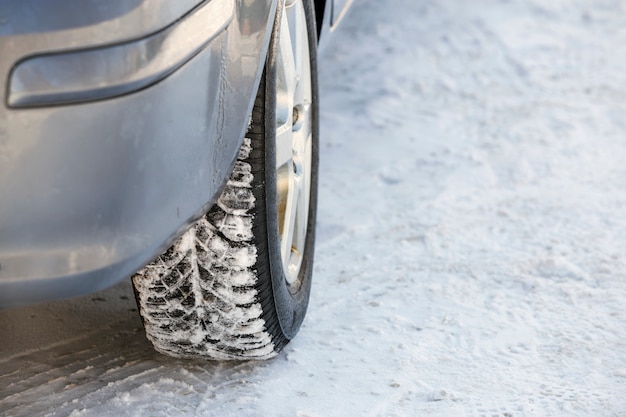 Het close-up van auto rijdt rubberband in diepe sneeuw. Transport- en veiligheidsconcept.