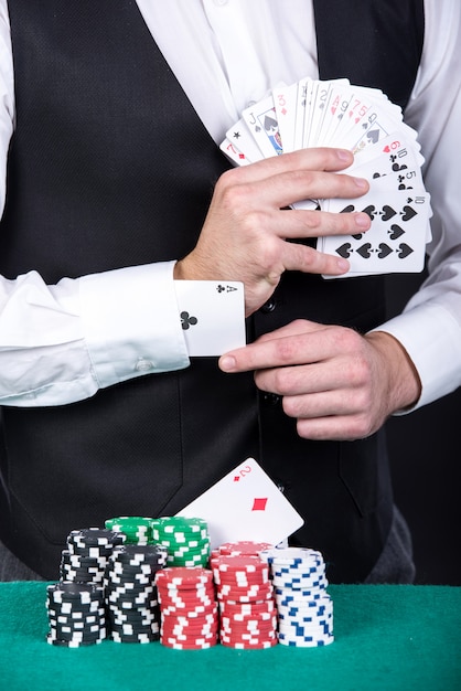 Het close-up van een croupier houdt speelkaarten.