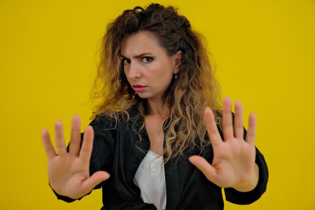 Het close-upportret van een mooi meisje op een gele achtergrondvrouw toont stopverbod menselijke emoties