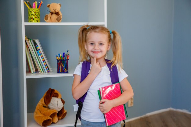 Foto het concept naar school van onderwijs. een klein meisje met een boek in haar handen