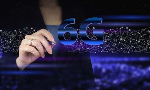 Foto het concept van 6g-netwerk highspeed mobiel internet nieuwe generatie netwerken hand met digitale grafische pen en tekenen van digitaal hologram 6g teken op stad donkere onscherpe achtergrond