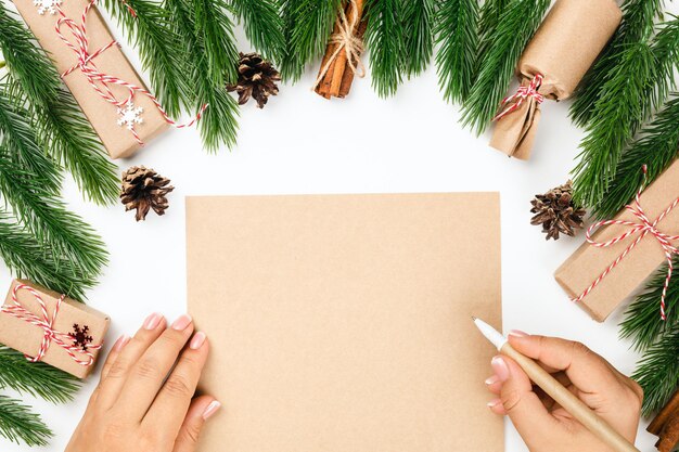 Het concept van de brief aan de vrouw van de kerstman handen op ambachtelijk papier in het kader van kerstbomen met dec...