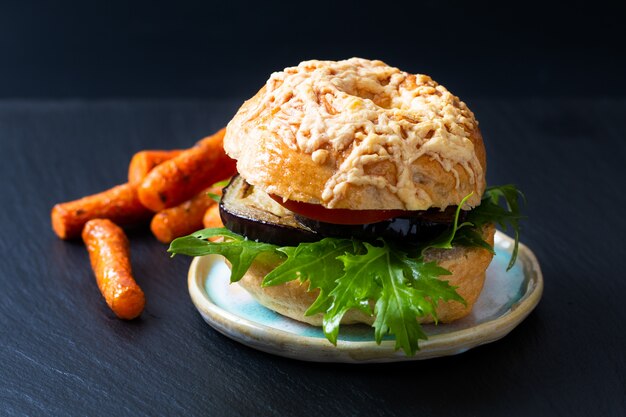 Het concept van de voedselbakkerij Eigengemaakte organische bagel vegetarische sandwich geroosterde aubergineraket en geroosterde wortelen