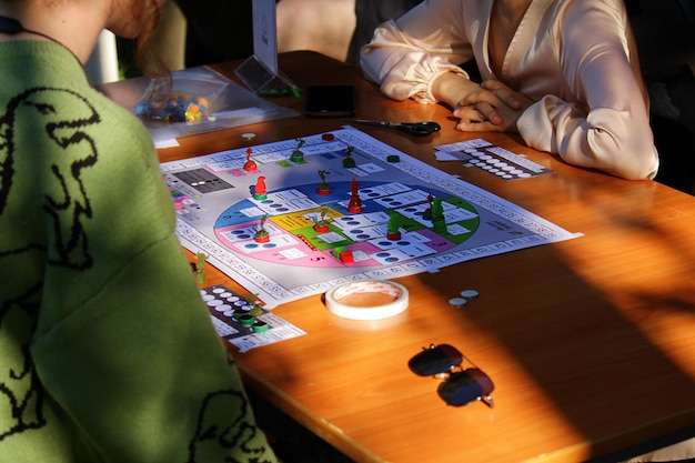 Het concept van een bordspel en vrijetijdsvolwassenen tieners of kinderen spelen bordspelhanden met pla