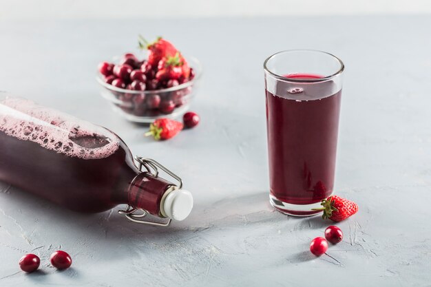 Het concept van een zomers verfrissend drankje gemaakt van rode bessen: Berry Morse gemaakt van verse aardbeien en veenbessen