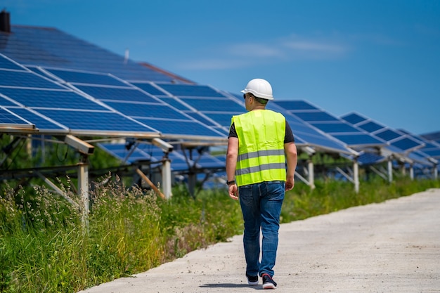 Het concept van groene nieuwe energie. Ingenieur bij zonnecentrale. Lopend naar de zonnepanelen.