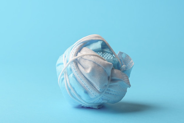 Het concept van het beëindigen van een pandemie. Verfrommeld medisch masker.