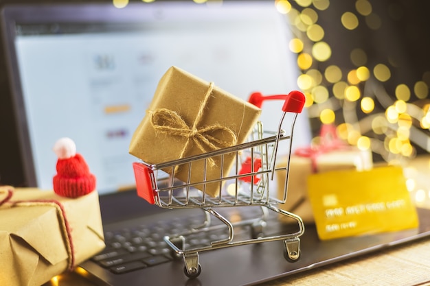 Het concept van online winkelen. cadeaus kopen. nieuwjaar, laptop, trolley geschenken, bankkaart