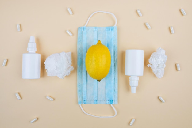 Het concept van seizoensgebonden ziekten Bovenaanzicht foto van medicijnspray en siroopfles pillen capsules thermometer servetten citroen op geïsoleerde beige achtergrond Loopneus en verkoudheid