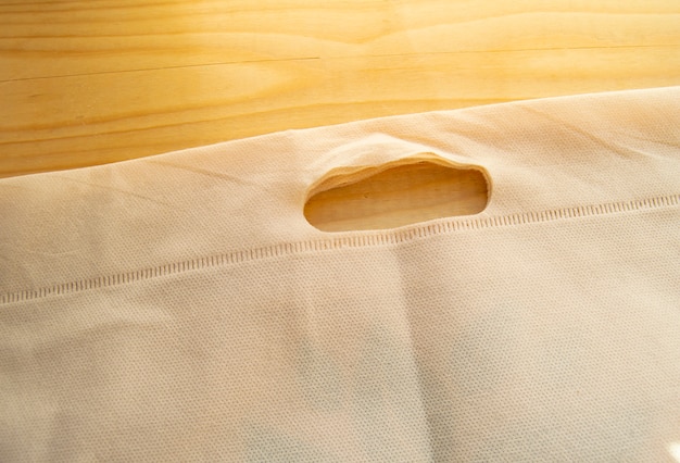 Het concept van verlaten van plastic zakken, eco-zak van niet-geweven stof, plat lag op een lichte houten achtergrond