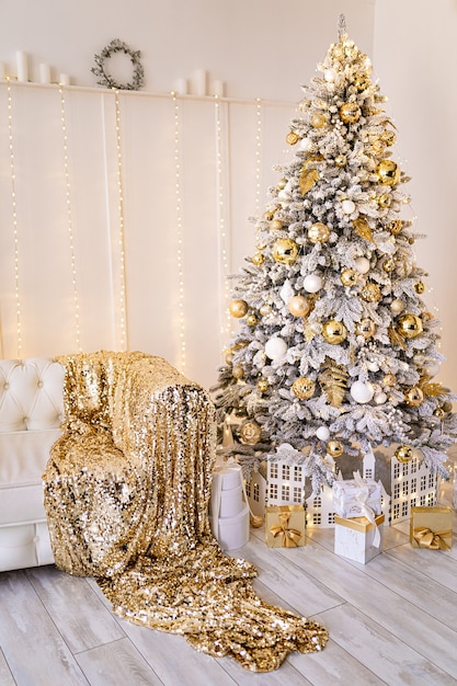 Het decor van kerst en nieuwjaar kerstboom met speelgoed en geschenken woonkamer met witte bank