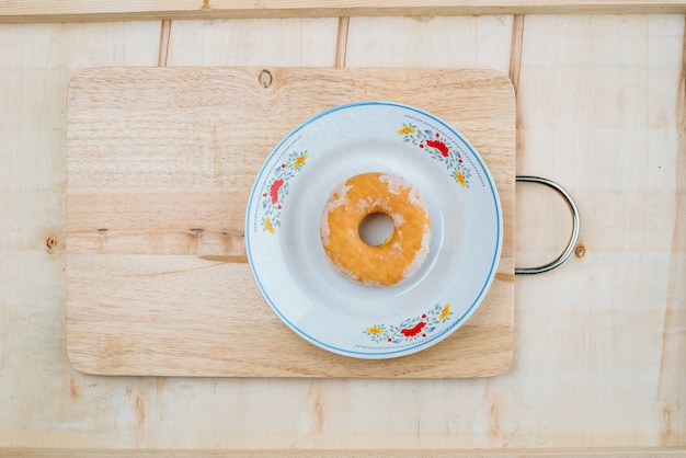 Het deeg is een cirkel van donuts die op een plank wordt geplaatst.