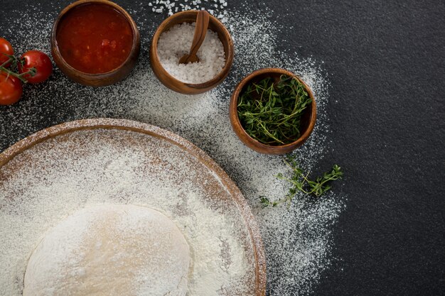 Het deegbal van de pizza op een houten dienblad