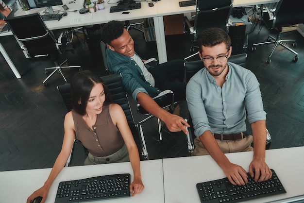 Het delen van frisse ideeën bovenaanzicht van jonge zakenmensen die op computers werken en praten met