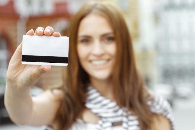 Het ding dat je nodig hebt om te winkelen Selectieve focusopname van een jonge glimlachende brunette shopper met creditcard