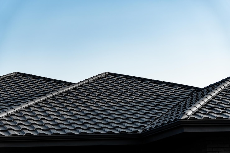 Foto het donkere tegeldak heeft een uniek patroon en elegante hellingen die een prachtig contrast vormen met de heldere blauwe lucht boven een huis in de buitenwijken tijdens de dag