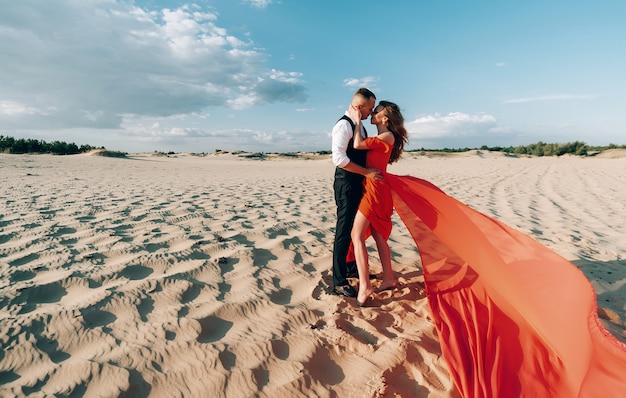 Het elegante mooie paar stellen op het strand